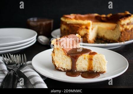 Scheibe Eierkuchen mit Rum Karamell Topping: Eine Scheibe Käsekuchen, beträufelt mit Karamellsoße Stockfoto