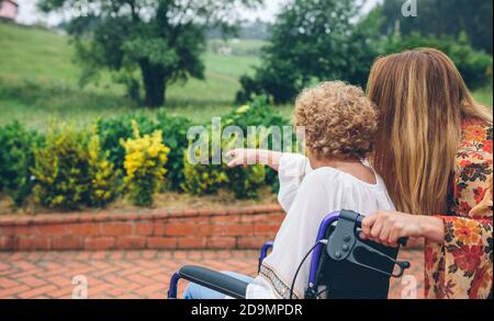 Ältere Frau in einem Rollstuhl mit Ihrer Tochter Stockfoto