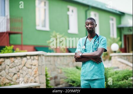 Porträt eines afrikanischen männlichen Arztes mit Stethoskop in grünem Mantel. Stockfoto