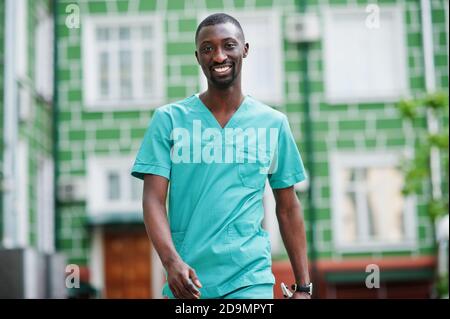 Porträt eines afrikanischen männlichen Arztes mit Stethoskop in grünem Mantel. Stockfoto