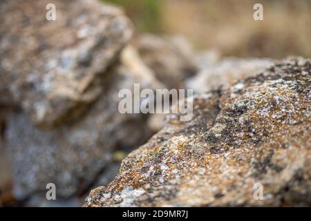 Abstrakter Hintergrund und Textur von Bergschichten und Rissen in Sedimentgestein auf Felswand. Klippe des Felsbergs. Stockfoto