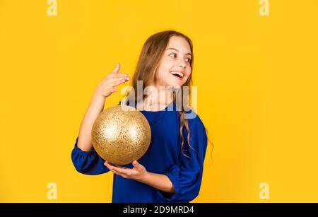 Dekoratives Accessoires Shop. Inspizieren Weihnachtsdekorationen. Goldene Einrichtung. Metallisch glänzend. Schimmernder Glitzer. Bereiten Sie Dekorationen im Voraus vor. Mädchen halten goldenen Ball Dekorationen für weihnachtsbaum. Stockfoto