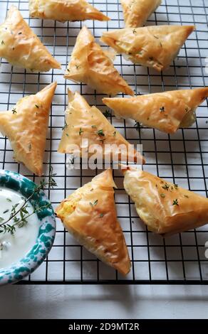 Griechische Küche. Tiropita, griechische Feta-Käse-Dreieck-Kuchen auf weißem Hintergrund. Draufsicht. Stockfoto