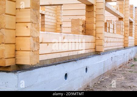 Bau eines Holzhauses auf Zementbasis, Fundament. Baubeginn, Erdgeschoss. Vorstadtimmobilien, Öko-Haus, Ferienhaus. Holz, wo Stockfoto