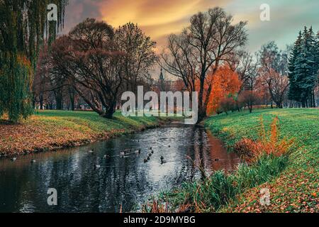 Marupite River im Rigaer Siegespark. Herbstlandschaft mit Bäumen und Fluss. Herrliche Landschaft. Stockfoto