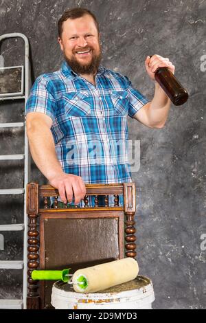 Fröhlicher bärtiger Vorarbeiter hat eine Pause mit einer Flasche Bier studio-Porträt Stockfoto