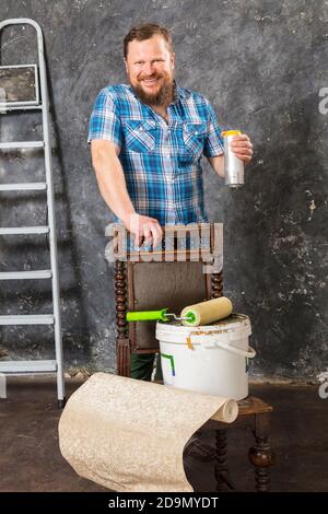 Fröhlicher bärtiger Vorarbeiter hat eine Pause mit einer Flasche Bier studio-Porträt Stockfoto