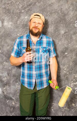 Fröhlicher bärtiger Vorarbeiter hat eine Pause mit einer Flasche Bier studio-Porträt Stockfoto