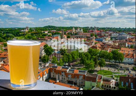 Ein Glas helles Bier mit Blick von oben auf das historische Stadtzentrum von Vilnius, Litauen Stockfoto