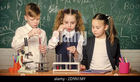 Schüler studieren Chemie in der Schule. Kinder genießen chemische Experimente. Chemische Substanz löst sich in einer anderen. Erkunden ist so aufregend. Eine chemische Reaktion tritt auf, wenn sich Substanz in neue Substanzen ändert. Stockfoto