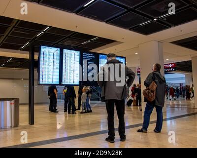 Schönefeld, 1. November 2020 - Passagiere am Flughafen Berlin Brandenburg (BER) stehen vor der Informationstafel Stockfoto