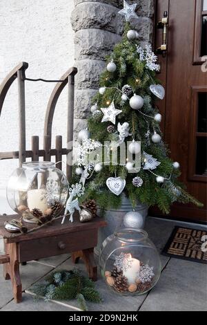 Weihnachtsbaum mit Metalldekorationen neben der Haustür NUR FÜR GROSSBRITANNIEN VERFÜGBAR – BITTE WENDEN SIE SICH AN DAS BÜRO Stockfoto