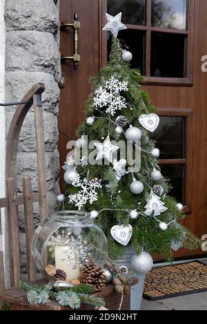 Weihnachtsbaum mit Metalldekorationen neben der Haustür NUR FÜR GROSSBRITANNIEN VERFÜGBAR – BITTE WENDEN SIE SICH AN DAS BÜRO Stockfoto