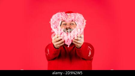 Lass mich dein Herz schmelzen. Begrüßen Sie Weihnachten in Ihrem Herzen. Schöner Mann Liebe Winterurlaub roten Hintergrund. Kerl tragen Weihnachtsmütze. Frohe weihnachten und Frohes neues Jahr. Verlieben Sie sich. Ich liebe dich. Stockfoto