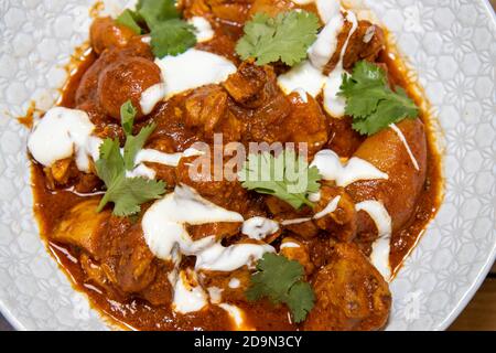 Ein Teller köstliche Butter Chili Huhn auf einer Holzküche Arbeitsfläche Stockfoto