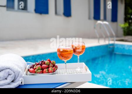 Cocktails auf einem Tablett mit Beeren am Pool Stockfoto