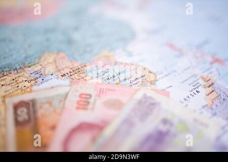 50 Kyat-Schein, 100 Baht-Schein und 100 Riels-Schein auf einer Karte Südostasiens Stockfoto