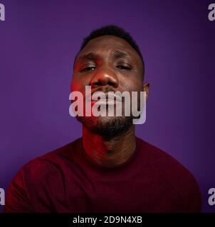Afrikanischer Mann mit erhobener Nase und Blick auf die Kamera. Nahaufnahme. Isoliert. Stockfoto