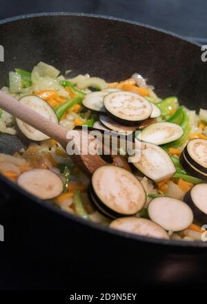 Auberginen ernten und vegetarisch kochen: Gesunde und nachhaltige Ernährung aus dem eigenen Garten. Vorbereitung der Gemüsesauce mit Auberginen. Stockfoto