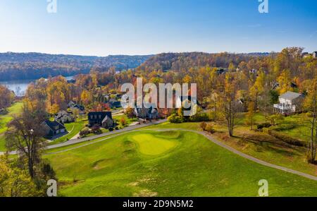 Luftdrohne Panorama von Einfamilienhäusern zwischen Golf gesetzt Fairway und Grüns am See im Herbst Stockfoto