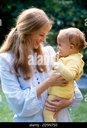 70ER JAHRE BLONDE MUTTER MIT LANGEN HAAREN HÄLT BABY IN GELB OUTFIT IN IHREN ARMEN AUF IHRER HÜFTE LÄCHELND MIT BLICK AUF JEDEN SONSTIGES - KB14915 PHT001 HARS NOSTALGIE ALTE MODE 1 JUGENDLICH KOMMUNIKATION LACHEN BLONDE SICHERHEIT JUNGE ERWACHSENE KLEINKIND SÖHNE ZUFRIEDEN FAMILIEN FREUDE LEBENSSTIL ZUFRIEDENHEIT ELTERNSCHAFT FRAUEN LÄNDLICHEN GESUNDHEIT HEIM LEBEN KOPIE RAUM FREUNDSCHAFT HALBE LÄNGE DAMEN PERSONEN MÄNNER GLÜCK FRÖHLICH SCHUTZ LÄCHELT FRÖHLICHE LANGE HAARE MUTTERSCHAFT UNTERSTÜTZEN ZUSAMMENARBEIT WACHSTUM JUVENILES MÜTTER ZWEISAMKEIT JUNGE ERWACHSENE FRAU KAUKASISCHE ETHNIE ALTMODISCH Stockfoto