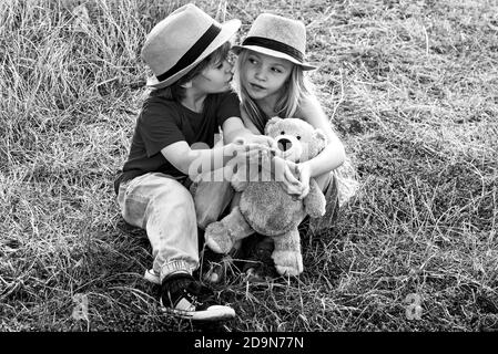 Nette kleine Kinder genießen auf dem Bauernhof. Amerikanisches Bauernleben. Glückliche Kinder Bauern Spaß auf dem Frühlingsfeld. Sommerurlaub. Stockfoto