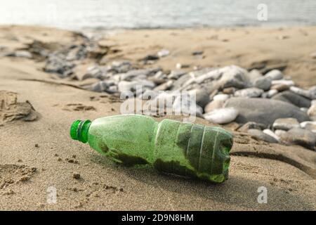 Grüne Plastikflasche Müll auf Meeresküste Ökosystem, Umweltverschmutzung abbandoned Probleme Stockfoto