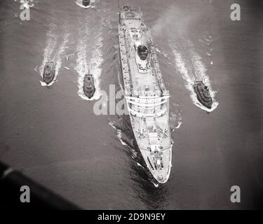 1950ER JAHRE 1953 ANKUNFT DES OCEAN-LINIENSCHIFFS SS ANDREA DORIA IN DEN HAFEN MIT BEGLEITENDEN SCHLEPPER NEW YORK CITY NEW YORK USA - S11960 RGE001 HARS BEGLEITENDE KOOPERATION BEI DER ANKUNFT JUNGFERNFAHRT OCEAN LINER SCHWARZ UND WEISS HUDSON RIVER MARITIM ALTMODISCHES VERSENKTES SCHLEPPER-SCHIFF Stockfoto