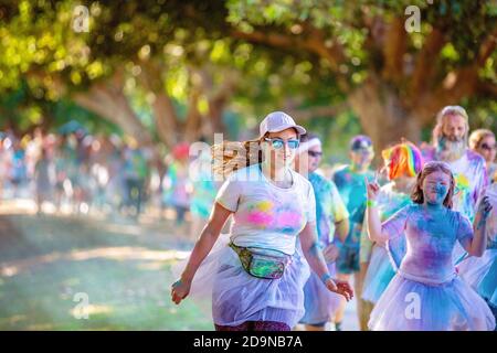 MACKAY, QUEENSLAND, AUSTRALIEN - JUNI 2019: Unbekannte Mädchen, die mit farbigem Pulver bedeckt sind, nehmen am Color Frenzy Fun Run Teil Stockfoto