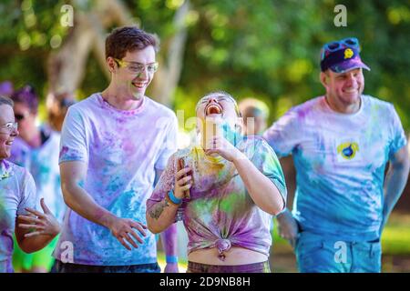 MACKAY, QUEENSLAND, AUSTRALIEN - JUNI 2019: Unbekannte junge Frau lacht laut mit Freunden in Color Frenzy Fun Run Stockfoto