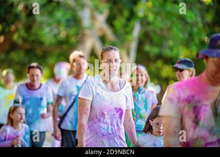 MACKAY, QUEENSLAND, AUSTRALIEN - JUNI 2019: Unbekannte Frau, die mit farbigem Pulver bespritzt ist und nach dem Color Frenzy Fun Run erschöpft aussieht Stockfoto