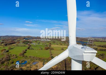 Luftaufnahme der großen Windkraftanlage stationär auf schöne walisische Landschaft. Saubere Energie-Konzept. Nahaufnahme der Blätter. Stockfoto