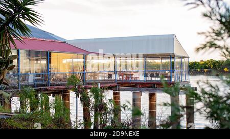 Mackay, Queensland, Australien - 12. Juli 2019: Menschen, die bei Sonnenuntergang im australischen Restaurant am Wasser am Fluss speisen Stockfoto