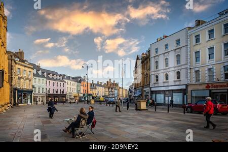 Geschäfte und Restaurants in Market Place bei Sonnenuntergang in Cirencester, Gloucestershire, Großbritannien am 4. November 2020 Stockfoto