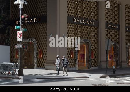 Zwei Männer stehen an der Ecke der Fifth Avenue und West 57th Street vor dem geschlossenen Bulgari Juweliergeschäft. Stockfoto