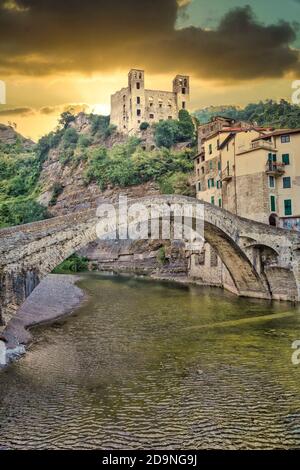 DOLCEACQUA, ITALIEN - CA. AUGUST 2020: Dolceacqua Panorama mit der antiken römischen Brücke aus Steinen und der Burg Stockfoto