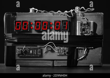 Terroristische Bedrohung. Sprengstoff mit Sprengkörper. Improvisierte Sprengvorrichtung. Bombe mit einem roten Timer auf schwarzem Hintergrund. Dynamit wird explodieren oder Stockfoto