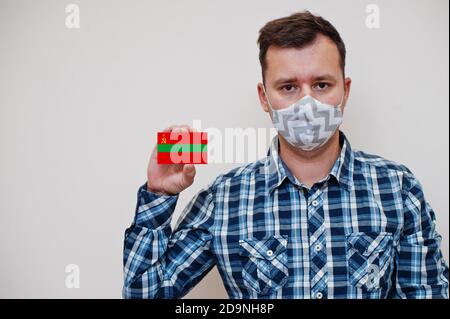 Mann im karierten Hemd zeigen Transnistria Flagge Karte in der Hand, tragen Schutzmaske isoliert auf weißem Hintergrund. Europa Länder Coronavirus Konzept. Stockfoto