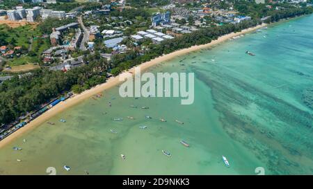 Luftdrohne Foto aus der Vogelperspektive von oben auf Asphalt Straße in der Nähe des Meeres mit langen Schwanz Fischerboote an phuket thailand Stockfoto