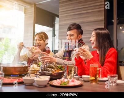 Glückliche Freunde, die Spaß im Hot Pot Restaurant haben Stockfoto