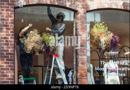 Toronto, Kanada. November 2020. Shop Assistenten tragen Gesichtsmasken schmücken ein Schaufenster in Toronto, Kanada, am 6. November 2020. Kanadas Arbeitslosenquote fiel auf 8.9 Prozent im Oktober von September neun Prozent, nach Statistik Kanada am Freitag. Quelle: Zou Zheng/Xinhua/Alamy Live News Stockfoto