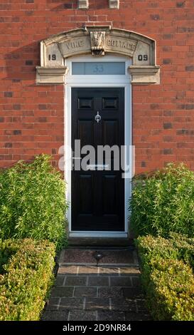 Schwarze viktorianische Eingangstür mit einem Bogensturz Stockfoto