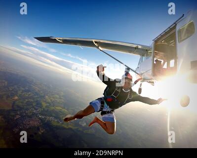 Barfußmann, der bei Sonnenuntergang aus dem Flugzeug springt. Stockfoto