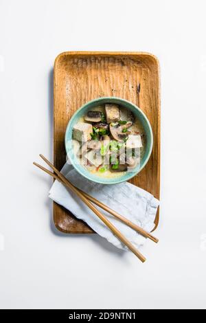 Tofu und Pilzsuppe in blauer Schüssel mit Essstäbchen Stockfoto