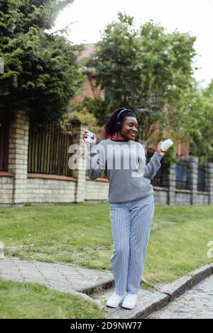 Afroamerikanische Frau, die auf der Straße tanzt und Musik hört Stockfoto