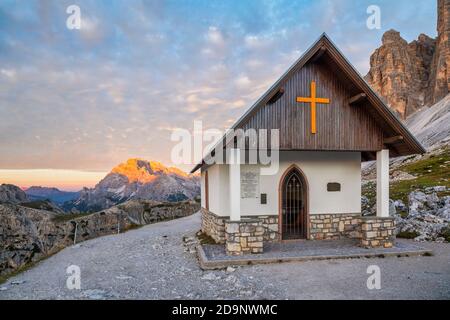 Kapelle der Alpini (Cappella degli Alpini) am Fuße des Tre Cime di Lavaredo, im Hintergrund der Monte Cristallo von der Sonne geküsst, Dolomiten Berge, Auronzo di Cadore, Provinz Belluno, Venetien, Italien, Europa Stockfoto