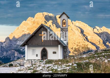 Kapelle der Alpini (Cappella degli Alpini) am Fuße des Tre Cime di Lavaredo, im Hintergrund der Monte Cristallo von der Sonne geküsst, Dolomiten Berge, Auronzo di Cadore, Provinz Belluno, Venetien, Italien, Europa Stockfoto