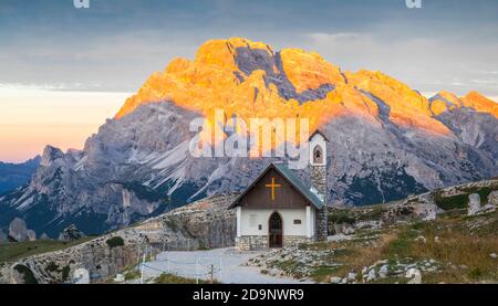 Kapelle der Alpini (Cappella degli Alpini) am Fuße des Tre Cime di Lavaredo, im Hintergrund der Monte Cristallo von der Sonne geküsst, Dolomiten Berge, Auronzo di Cadore, Provinz Belluno, Venetien, Italien, Europa Stockfoto