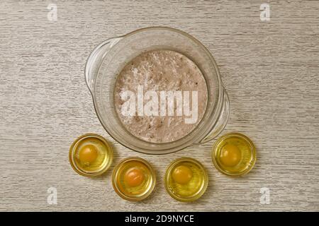 Der Prozess der Zugabe von Eiern zu fermentierten Hefe sprudeln in Milch. Stockfoto