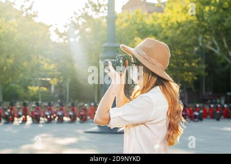Professionelle Fotografin mit Gesichtsmaske und Aufnahmen im Freien während einer Coronavirus-Pandemie. Frau mit Vintage-Kamera Stockfoto